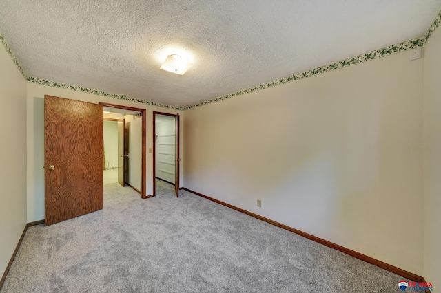 unfurnished bedroom featuring light carpet and a textured ceiling