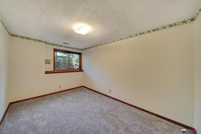 empty room featuring carpet and a textured ceiling