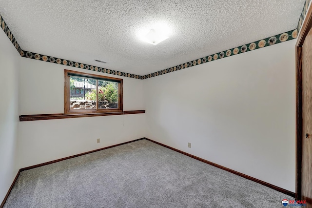 unfurnished room with carpet flooring and a textured ceiling