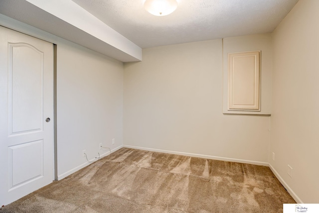 basement featuring carpet flooring and a textured ceiling