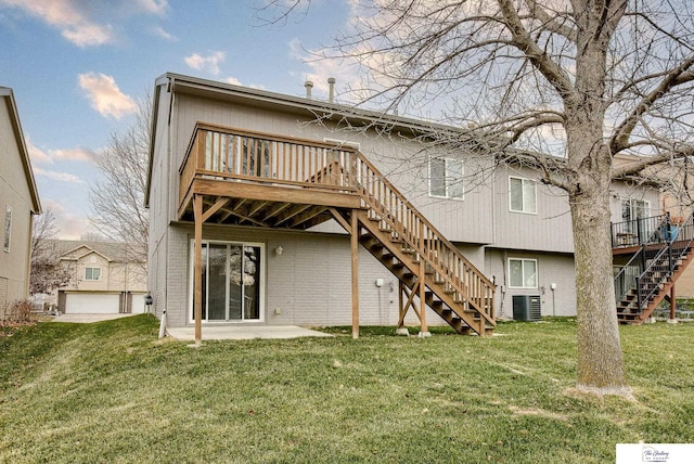 rear view of property featuring a lawn, a wooden deck, and central AC