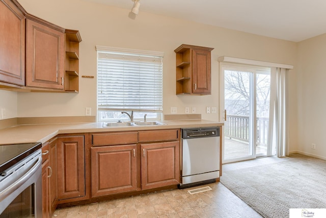 kitchen with stainless steel dishwasher, stove, light colored carpet, and sink