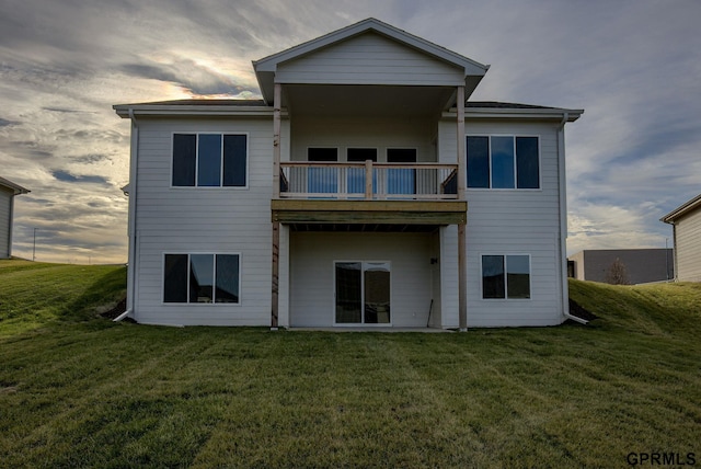 back of house featuring a yard and a balcony