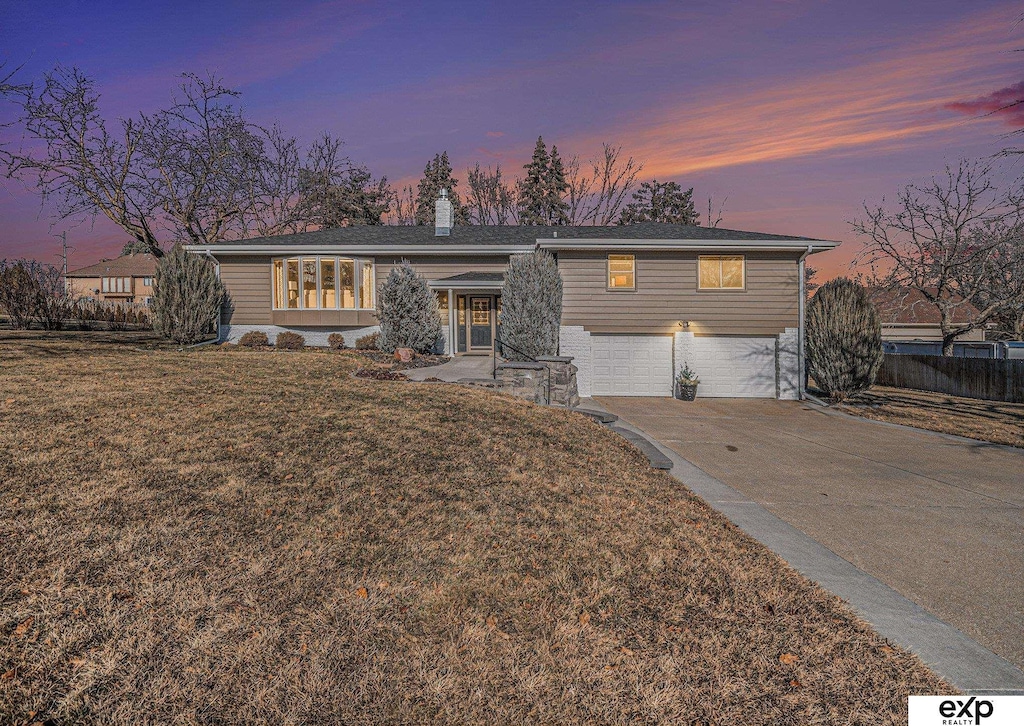 ranch-style home featuring a yard and a garage