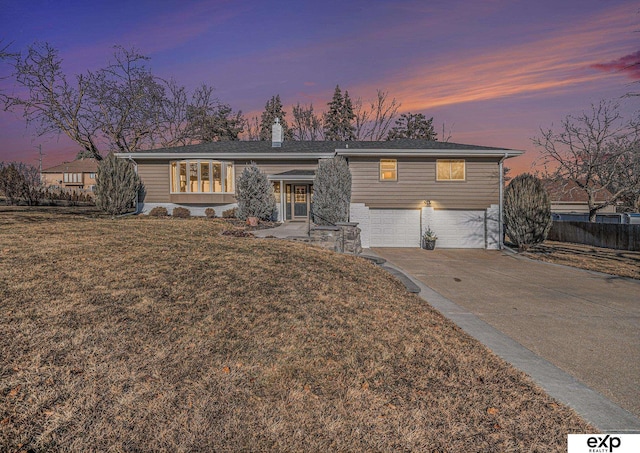 ranch-style home featuring a yard and a garage