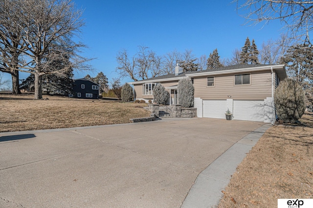 raised ranch with a front yard and a garage