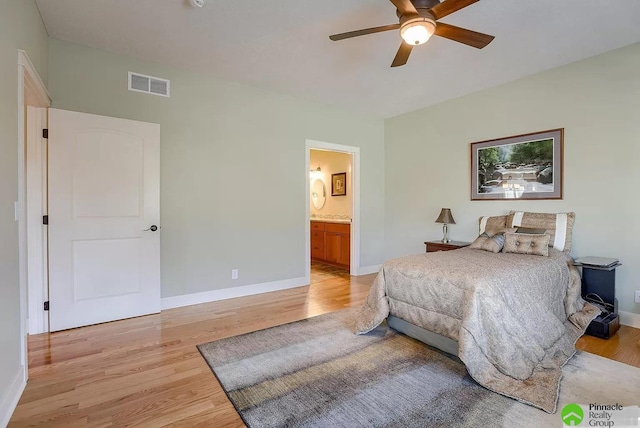 bedroom with light wood-type flooring, ensuite bathroom, and ceiling fan