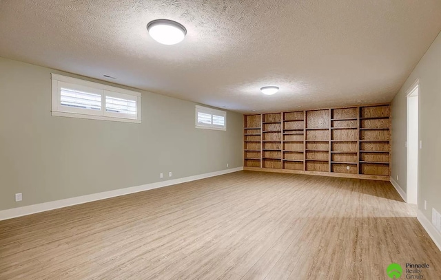 basement featuring hardwood / wood-style floors and a textured ceiling