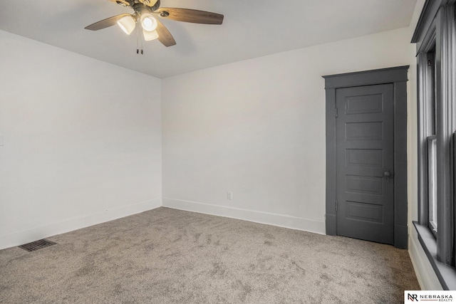 spare room featuring ceiling fan and carpet