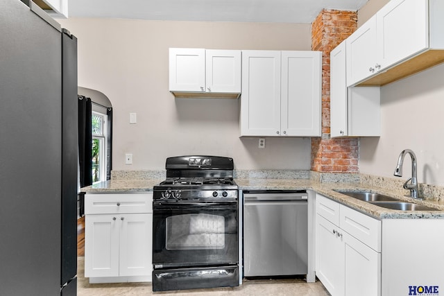 kitchen featuring stainless steel appliances, white cabinetry, and sink