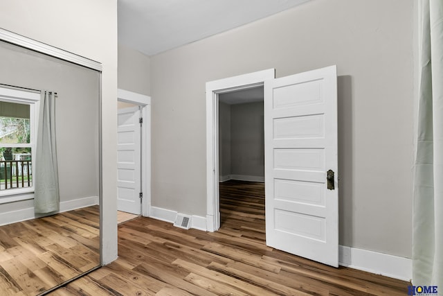 unfurnished bedroom with wood-type flooring and a closet