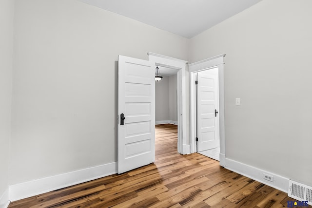 unfurnished room with wood-type flooring