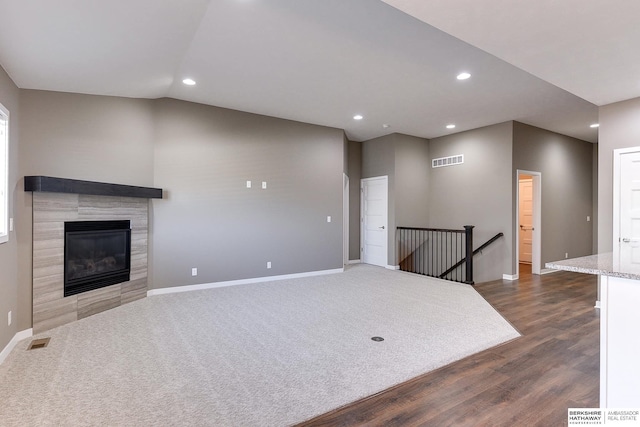 living room featuring a fireplace, dark hardwood / wood-style flooring, and vaulted ceiling