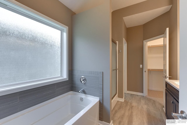 bathroom featuring hardwood / wood-style flooring, vanity, and shower with separate bathtub