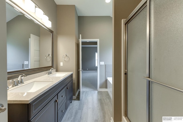 bathroom with vanity, wood-type flooring, and shower with separate bathtub