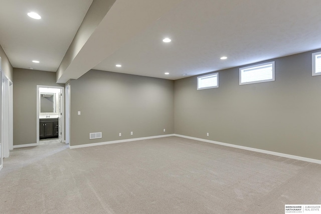 basement featuring sink and light colored carpet