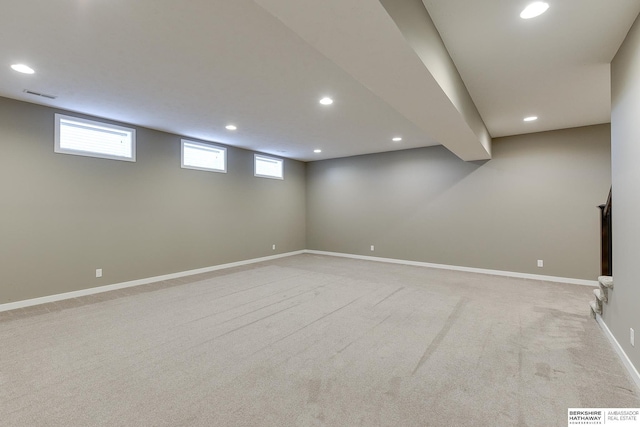 basement featuring a wealth of natural light and light colored carpet