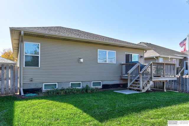 back of property with a lawn and a deck