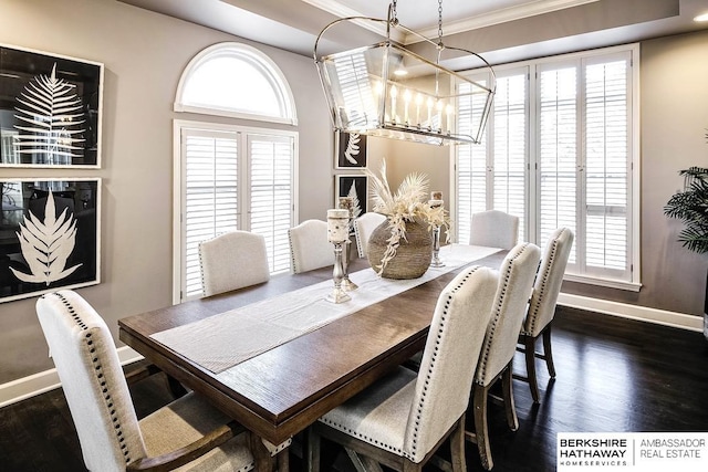 dining space featuring dark wood-type flooring, a notable chandelier, and ornamental molding