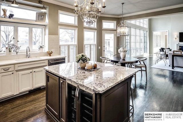 kitchen with white cabinets, pendant lighting, a healthy amount of sunlight, and sink