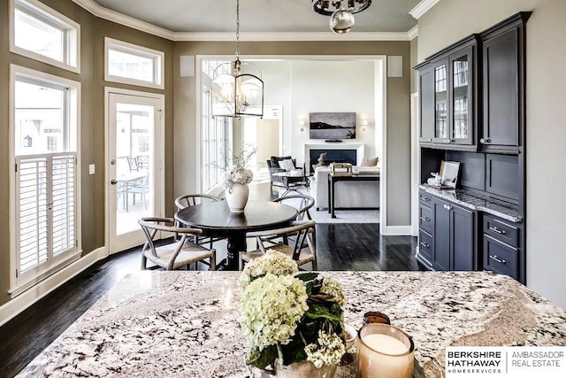 dining room with a notable chandelier, dark hardwood / wood-style flooring, and crown molding