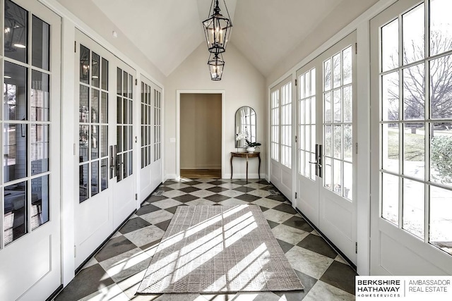 sunroom with french doors, lofted ceiling, and an inviting chandelier