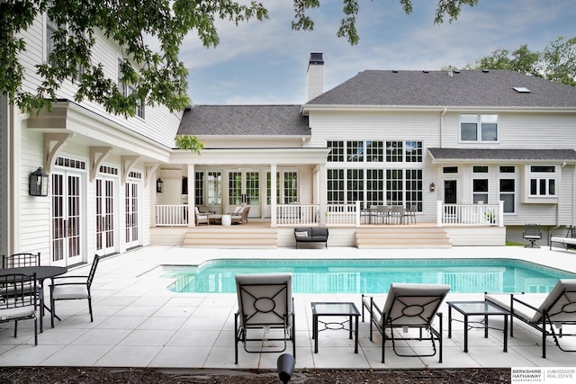 view of swimming pool with an outdoor living space, a patio, and french doors