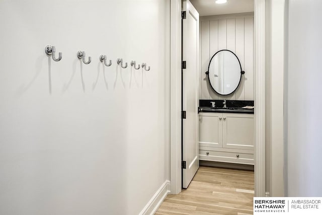 hallway with sink and light wood-type flooring