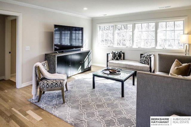 living room featuring crown molding, a healthy amount of sunlight, and wood-type flooring