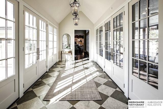 doorway featuring french doors, a chandelier, and vaulted ceiling