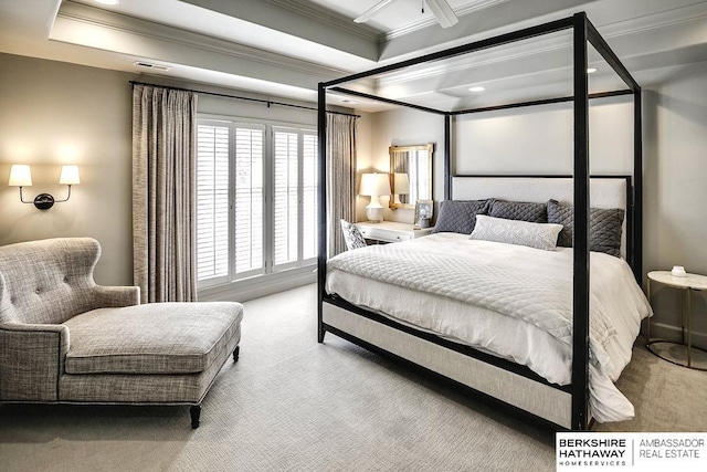 carpeted bedroom featuring a tray ceiling and crown molding