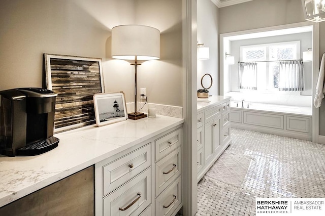 bathroom featuring tile patterned flooring, vanity, crown molding, and a bathing tub