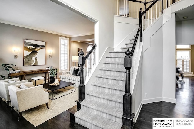 stairway with wood-type flooring and crown molding