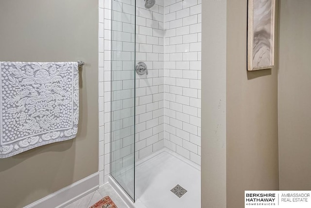 bathroom with a tile shower and tile patterned floors