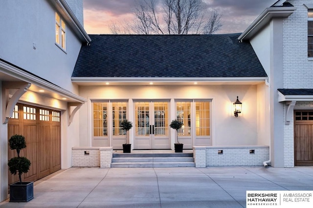 exterior entry at dusk with a garage