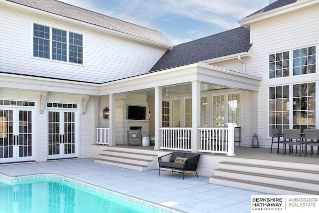 back of property with a fireplace and a patio