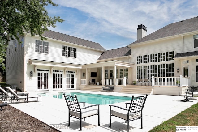 view of pool with french doors, a patio, and a deck