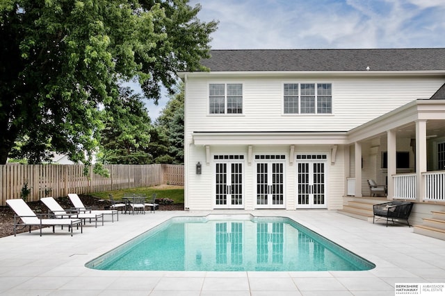 rear view of house featuring a fenced in pool, a patio area, and french doors