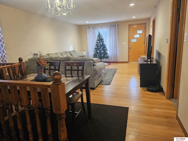 dining space with light hardwood / wood-style floors and a notable chandelier