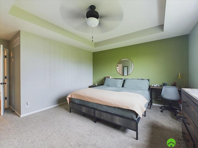 bedroom with visible vents, ceiling fan, baseboards, carpet, and a tray ceiling