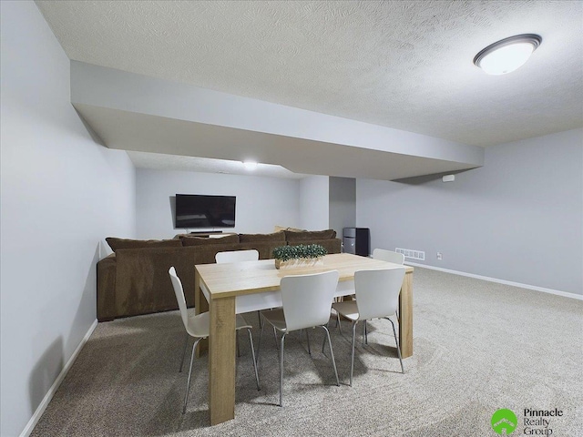 dining room with carpet and a textured ceiling