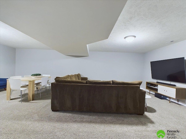 carpeted living room featuring visible vents and a textured ceiling