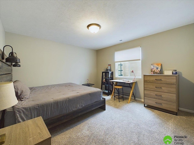 bedroom with visible vents, light colored carpet, a textured ceiling, and baseboards