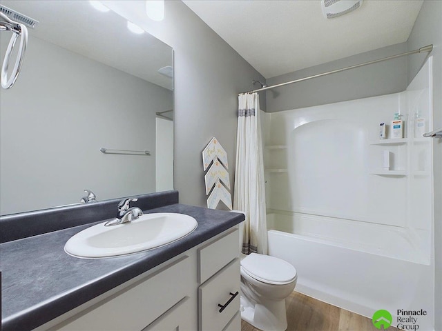 full bath featuring visible vents, toilet, shower / bath combo, wood finished floors, and vanity