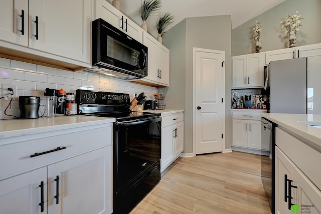 kitchen with light wood-type flooring, black appliances, white cabinetry, light countertops, and decorative backsplash