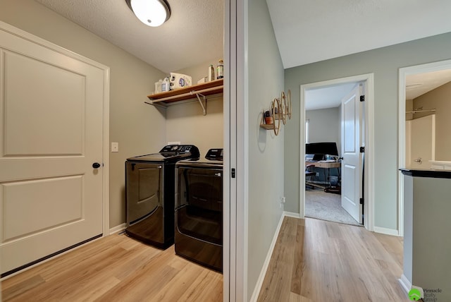 laundry room with laundry area, separate washer and dryer, light wood-type flooring, and baseboards