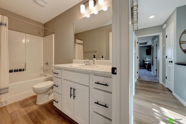 bathroom with visible vents, shower / bath combo with shower curtain, wood finished floors, and vanity