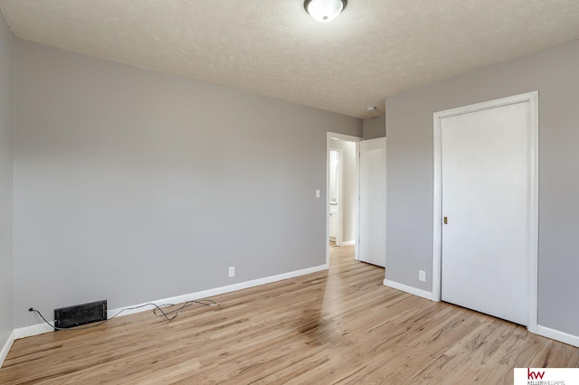 unfurnished bedroom featuring a textured ceiling and light hardwood / wood-style flooring