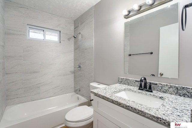 full bathroom featuring vanity, a textured ceiling, toilet, and tiled shower / bath combo