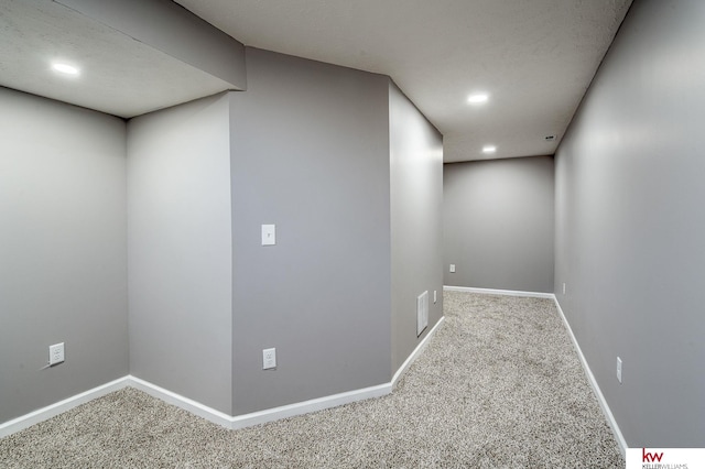 basement featuring carpet and a textured ceiling